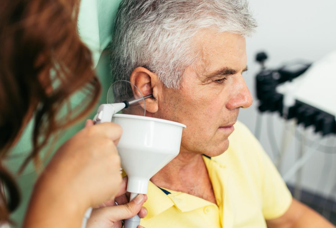 Man having ear irrigation performed