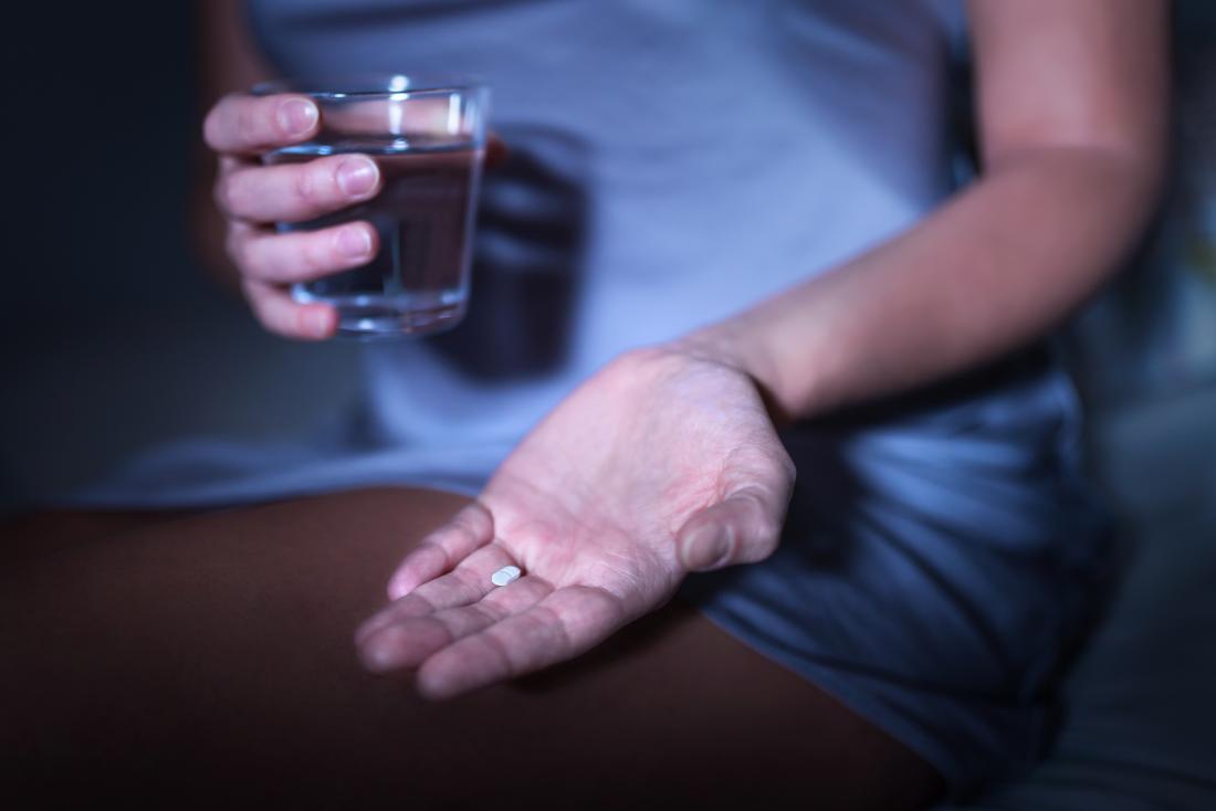 person holding a melatonin pill for sleep