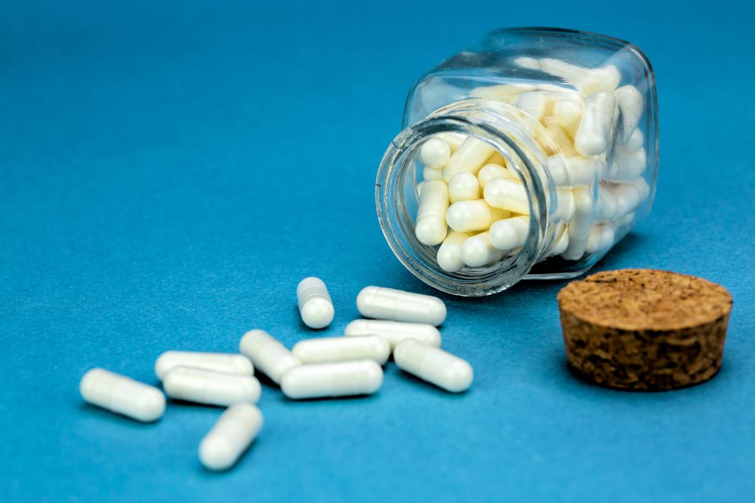 small jar of white capsules