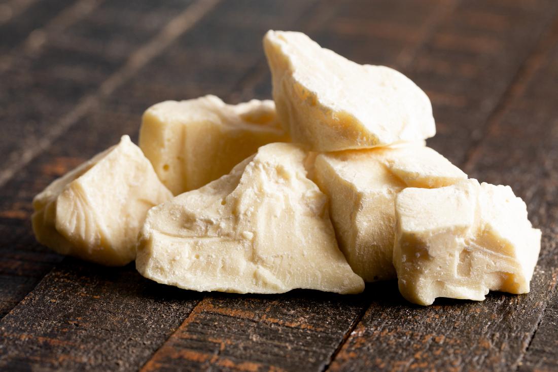 chunks of cocoa butter on wooden surface