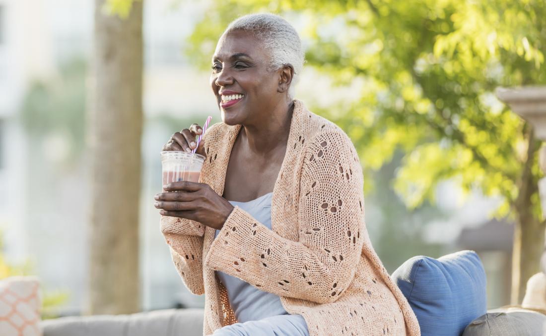 Woman drinking smoothie or juice outside