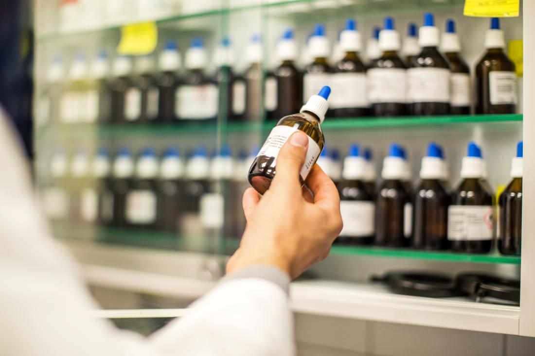close up of pharmacist's hand holding homeopathic drug