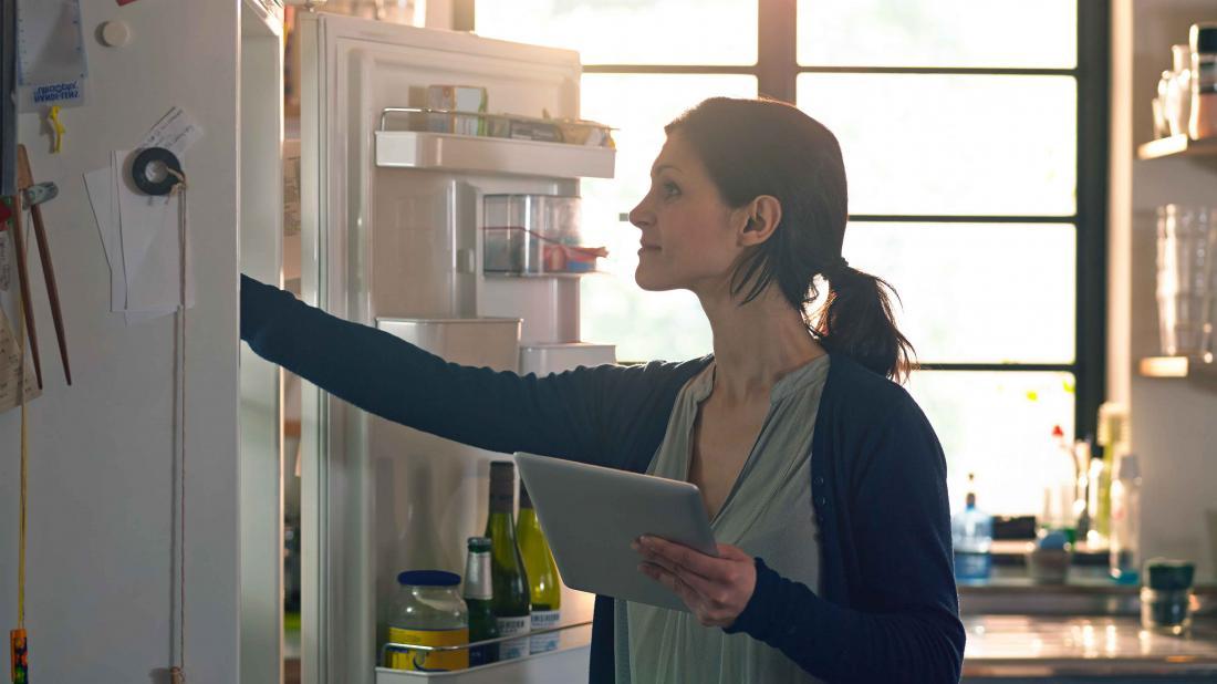 a woman looking in the fridge for food that may help in her heavy metal detox