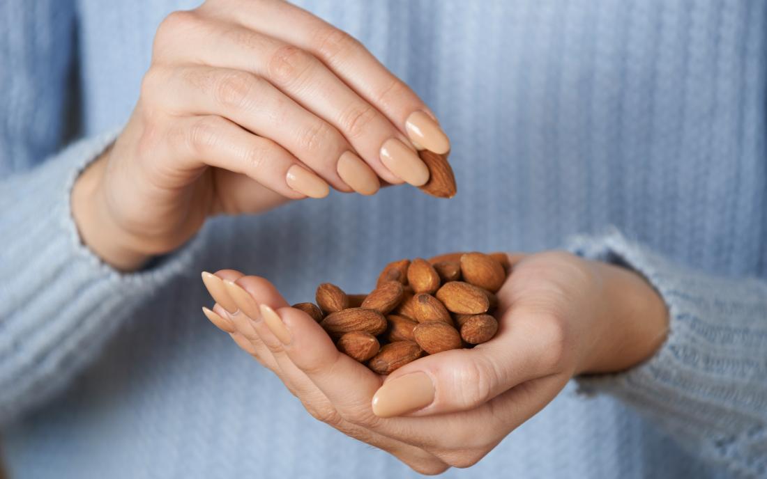 a dosage of nuts with nCoq10 in a womans hand