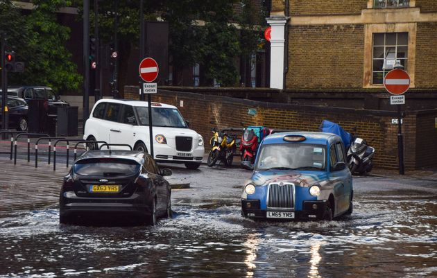 A taxi drives through a flooded Farringdon Lane in central London after a day of heavy rain in the capital...
