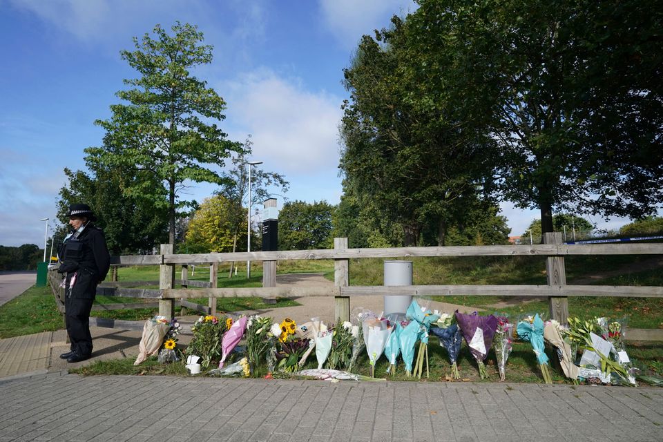 A police officer stands by floral tributes at Cator Park in Kidbrooke, near to the area where the body...