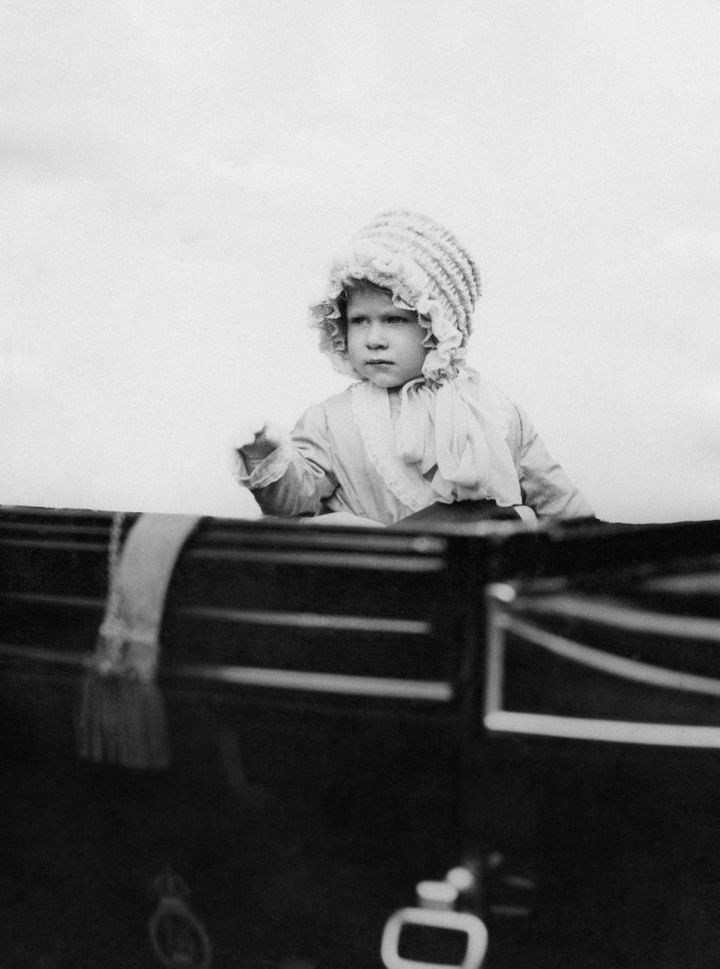 Princess Elizabeth waves from her carriage in London in 1928