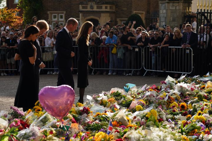The royal couples look at the piles of floral tributes lining the road in Windsor.