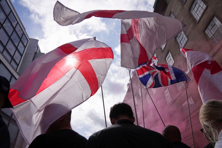 Demonstrators carry England and Union Jack flags during a Tommy Robinson-led Unite the Kingdom march and rally in London, Saturday Sept. 13, 2025.