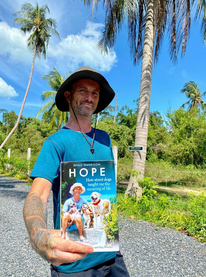The author holding the first book he published, "Hope: How Street Dogs Taught Me the Meaning of Life."