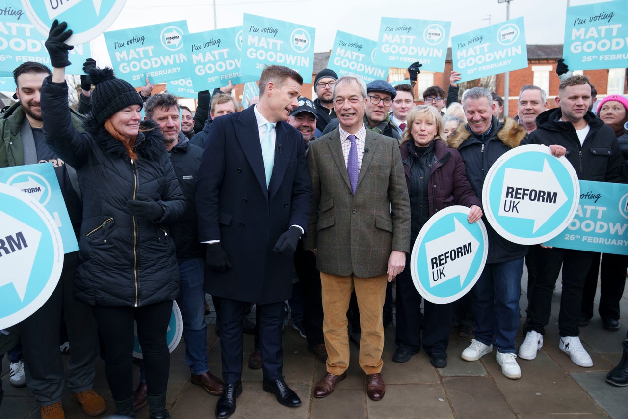 Reform leader Nigel Farage, centre right, stands with prospective candidate Matt Goodwin, centre left, and supporters during a campaign visit to Gorton and Denton in Manchester, England, Friday, Jan. 30, 2026.