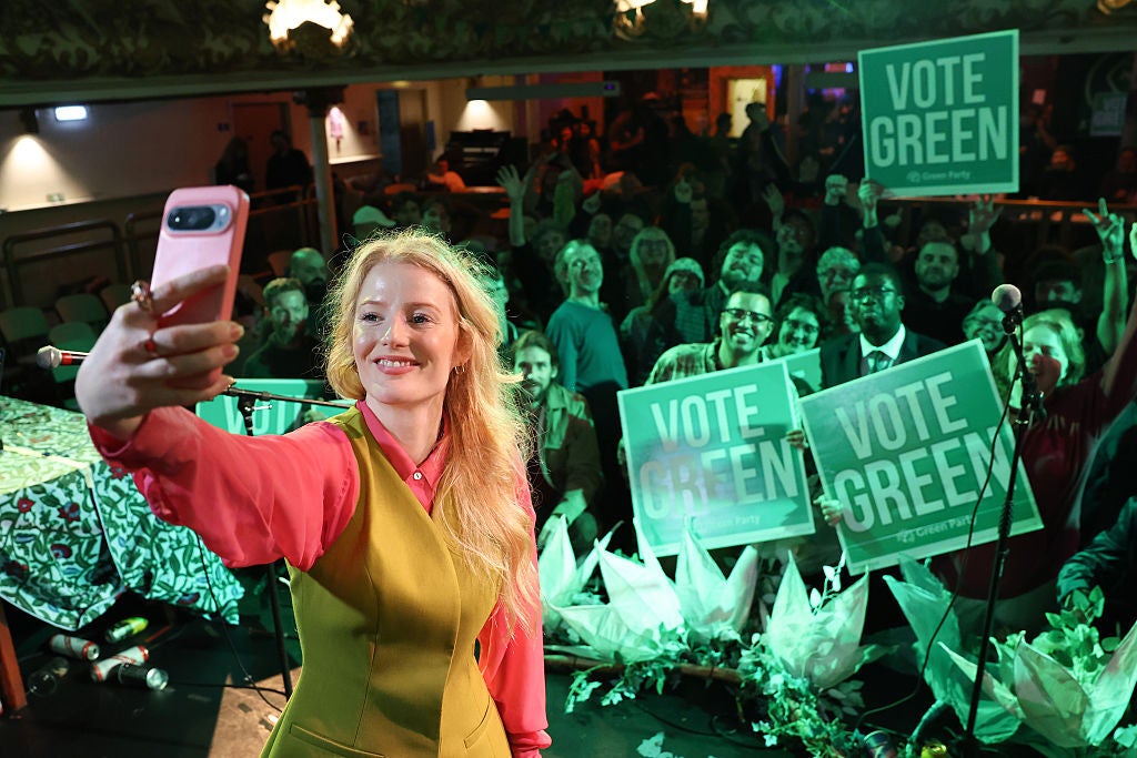 Green Party candidate and winner Hannah Spencer celebrates at an election rally with supporters.