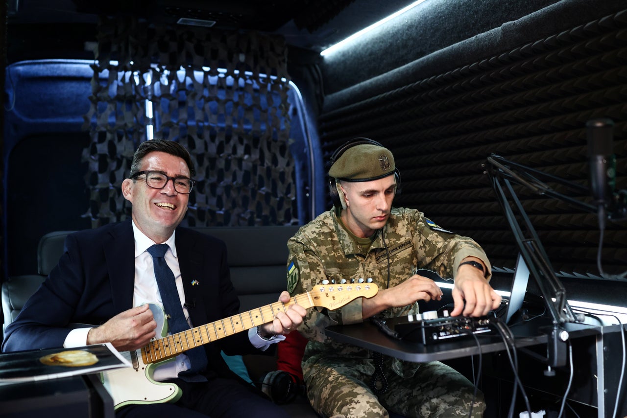 Burnham plays the guitar in the mobile recording studio of the military and artistic unit in Kyiv.